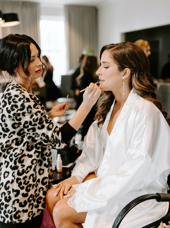 The bride gets her wedding makeup and hair done for her winter wedding in Houston.