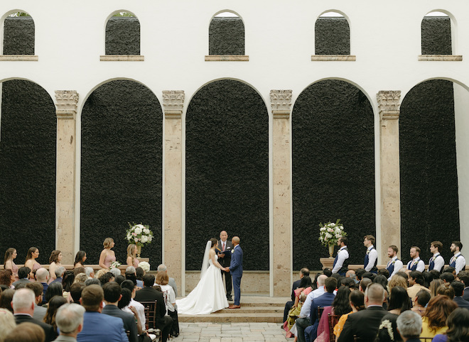 The bride and groom exchange vows at their outdoor wedding ceremony next to the venue's Waterwall. 