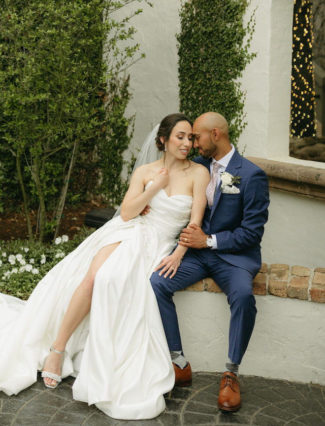 The groom presses his forehead on the brides cheek on their white, blush and red Indian-fusion wedding day. 