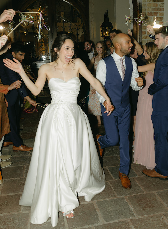 The bride and groom exit their white, blush and red Indian-fusion wedding at the Bell Tower on 34th.