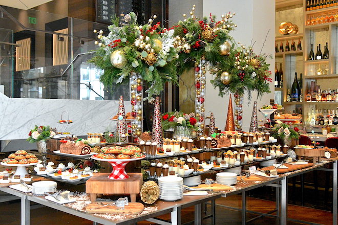 Table decorated with tall floral arrangements, Christmas decorations and desserts at The Post Oak Hotel at Uptown Houston's restaurant, Bloom and Bee.