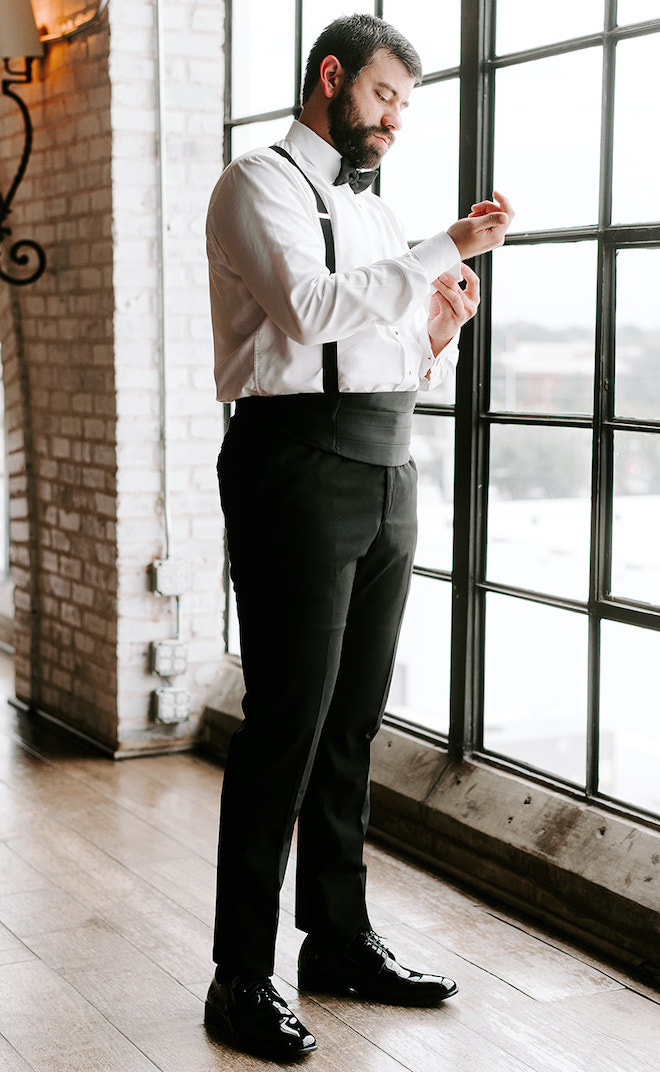 The groom gets ready and buttons his cufflinks for his downtown wedding at The Astorian.