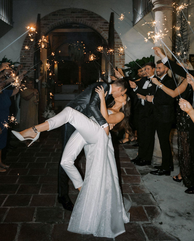 Bride and groom kissing during their sparkler sendoff on New Year's Eve. 