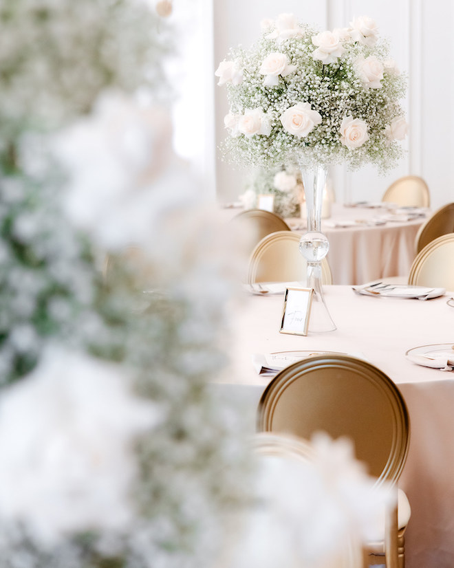 A floral centerpiece of white roses and baby breath at the wedding reception.