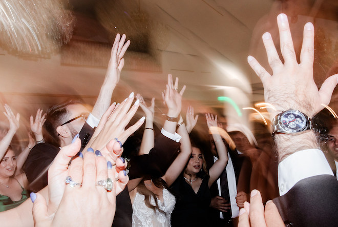 The bride and groom dance with their guests at their wedding reception.