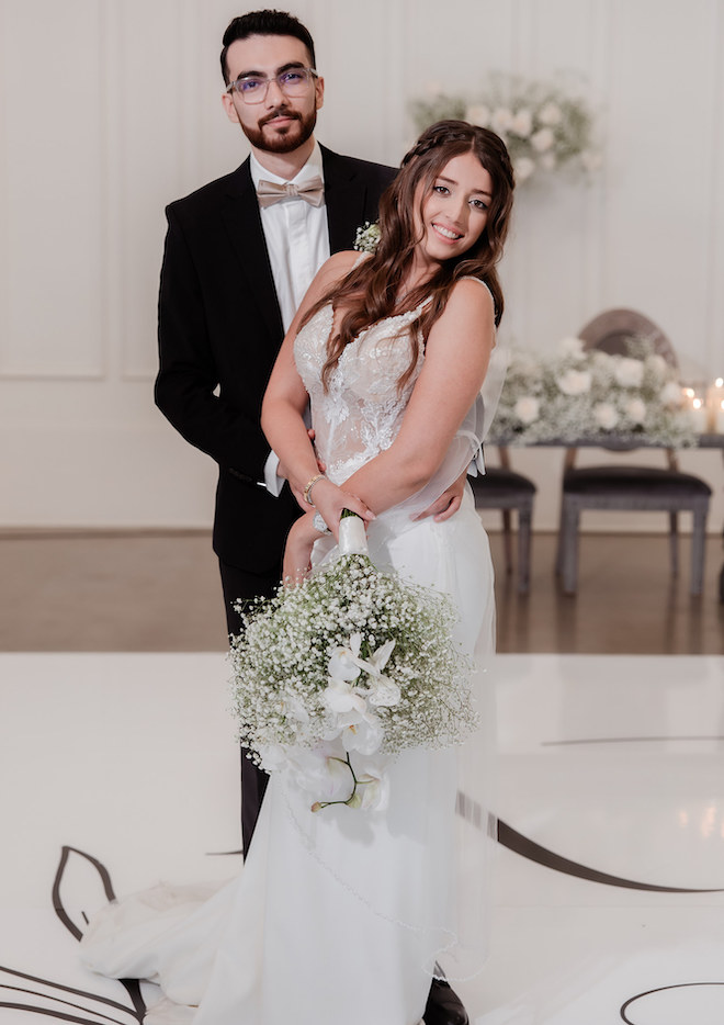 The bride and groom pose in the wedding venue's reception space. 