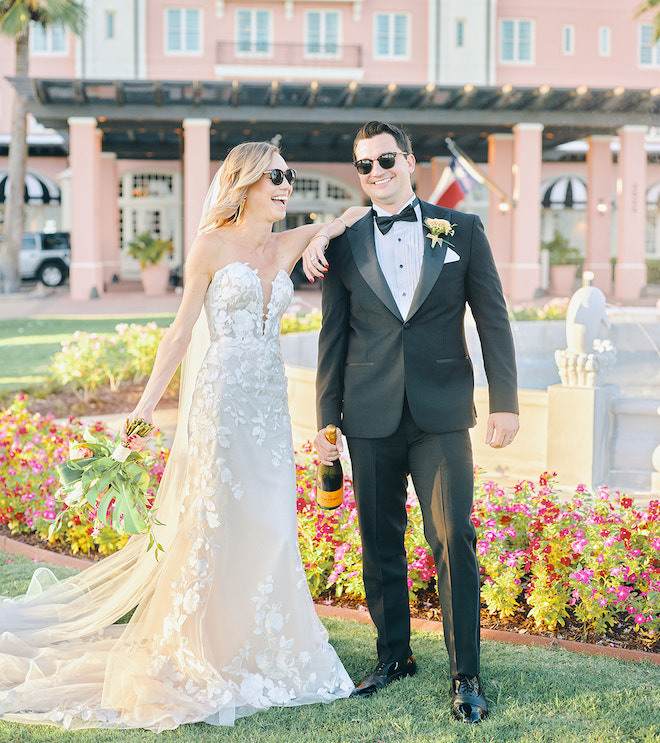 Bride and groom wearing sunglasses and smiling on the Center Lawn of Grand Galvez.