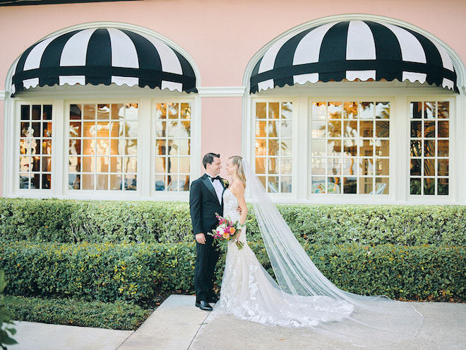 The bride and groom smiling at each other in front of the Grand Galvez. 