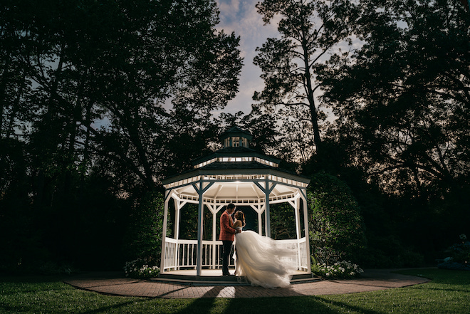 A couple under a gazebo at night. 