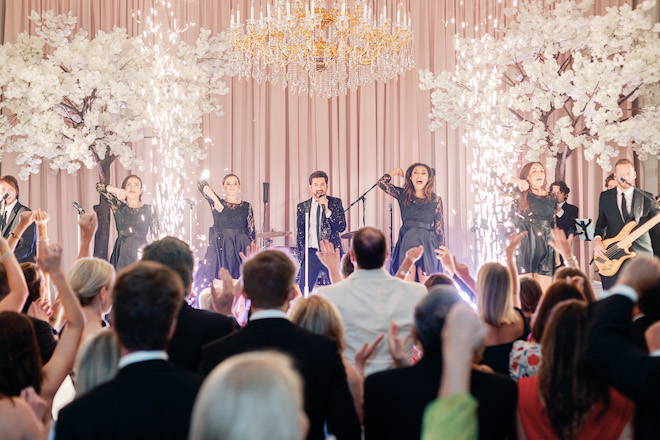 A band performing on stage with sparklers behind them. 