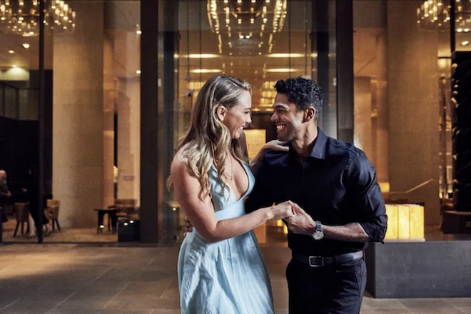 The couple hold hands while smiling at each other at the Hyatt Regency Lost Pines Resort & Spa.