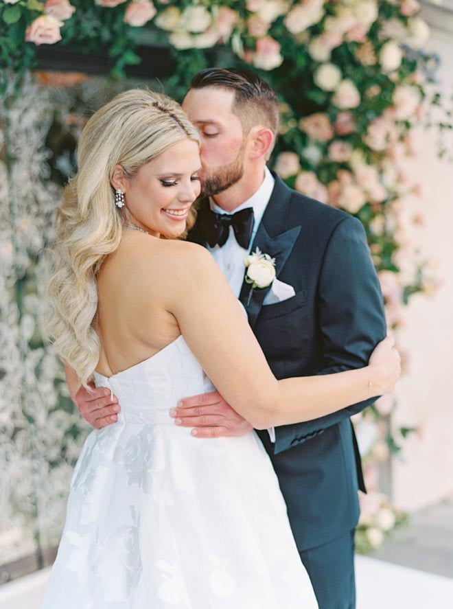 The groom kissing the bride's cheek outside of Corinthian Houston.