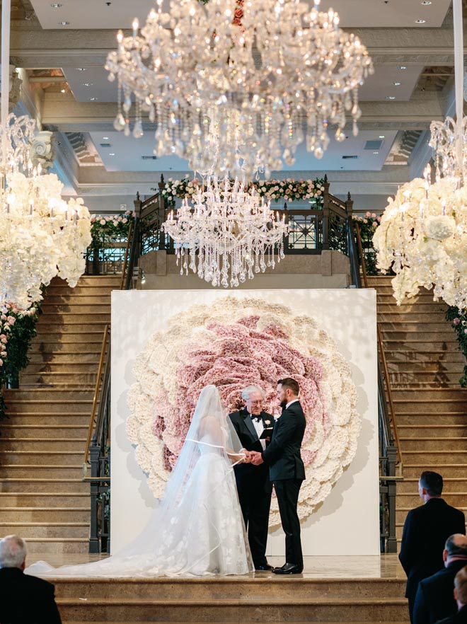 The bride and groom holding hands at the altar during the ceremony. 