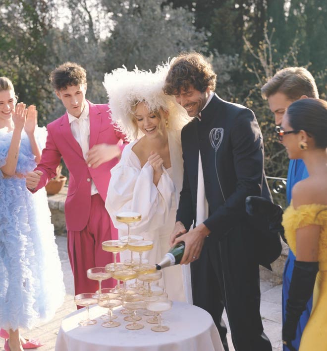 The bride and groom pouring champagne in a champagne tower. 