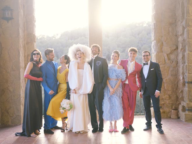 The bride and groom laughing with their wedding party. 