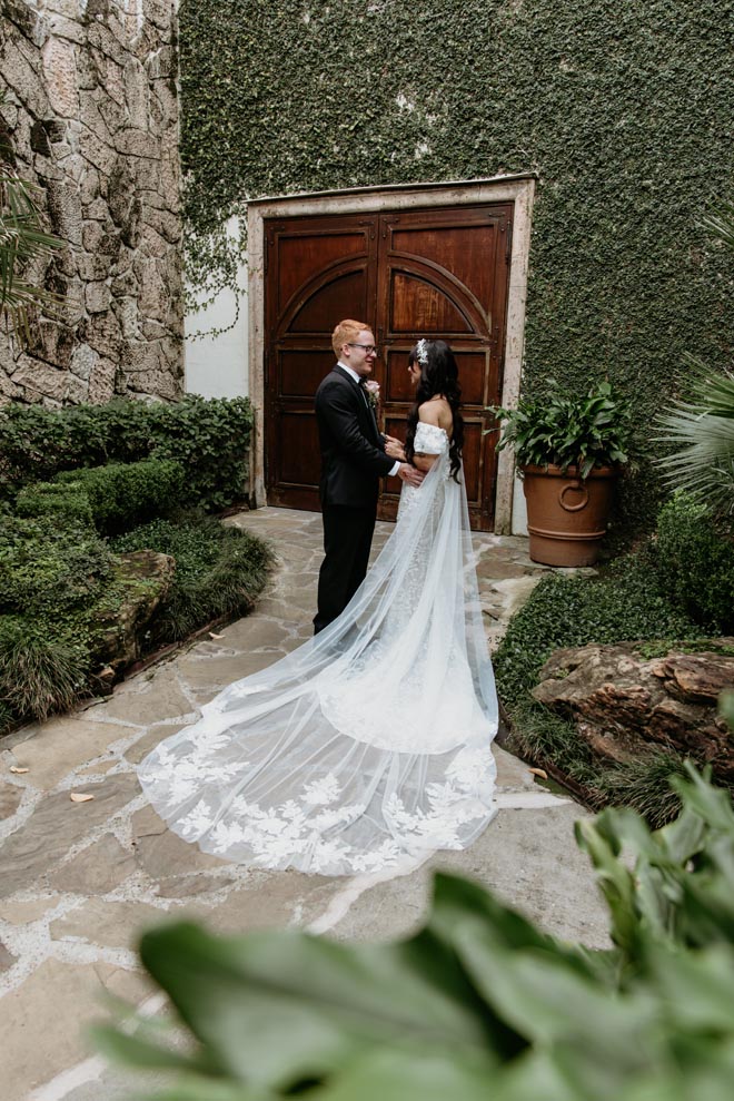 The bride and groom share a private first look outside their wedding venue. 