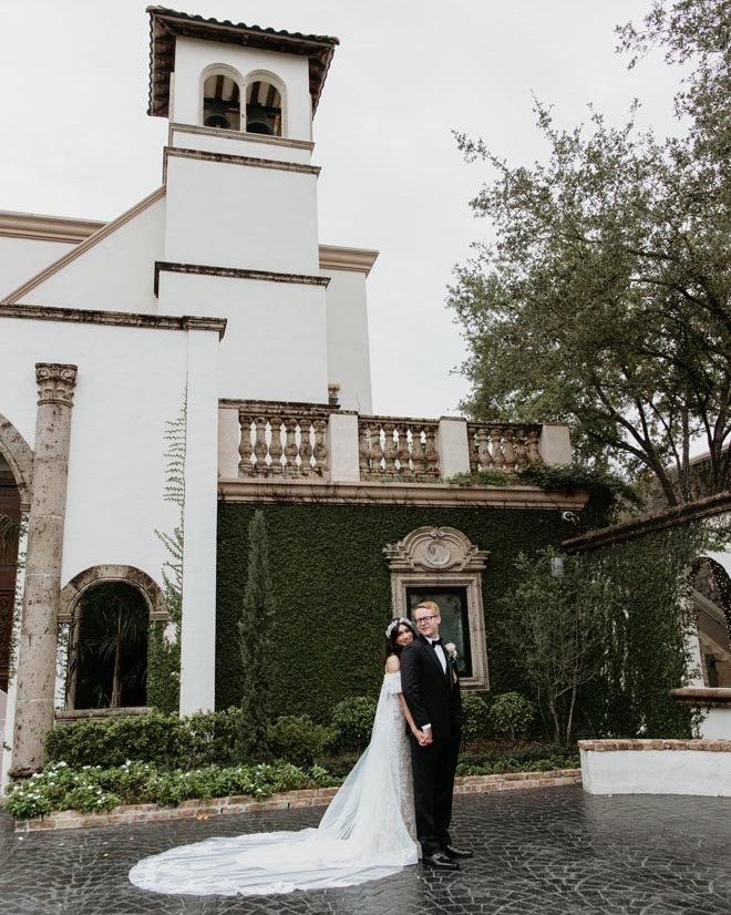 The bride and groom stand outside their wedding venue in Houston, The Bell Tower on 34th.