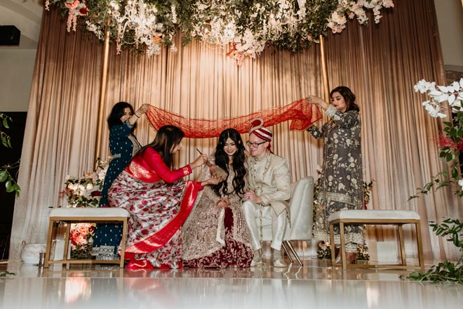 The bride and groom participate in Bengali traditions at their wedding reception at the Bell Tower on 34th. 