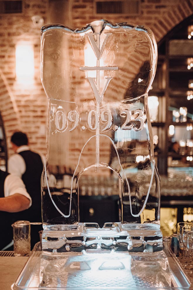 An ice sculpture shaped into a tooth is detailed in the couple's wedding date and initials. 