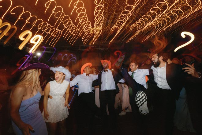 The bride and groom dance with family and friends at their wedding reception.