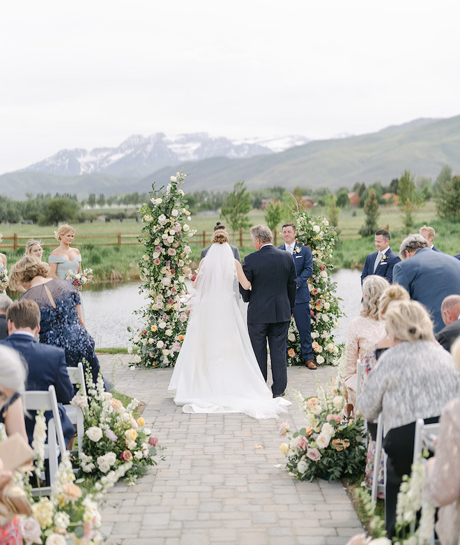 The bride and her father walking down the aisle. 