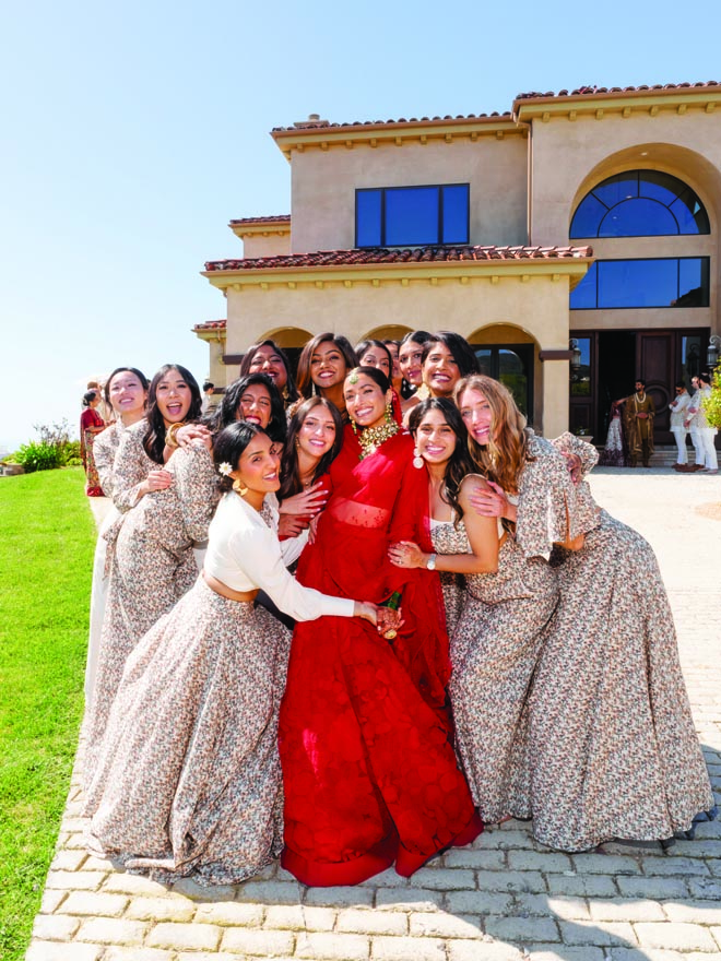 The bride and her friends smile outside of a Malibu home. 