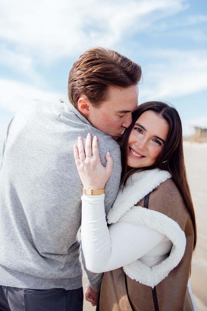 The boy kisses his fiancée on the cheek after their dream proposal. 