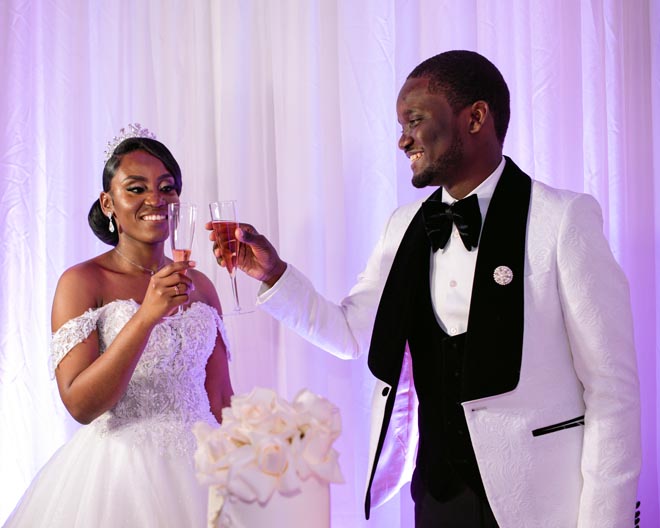 The bride and groom toast with champagne at their intimate ballroom wedding.