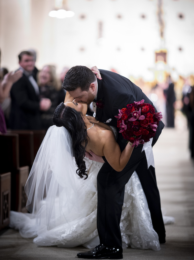 The bride and groom share a kiss walking down the aisle after the wedding ceremony.