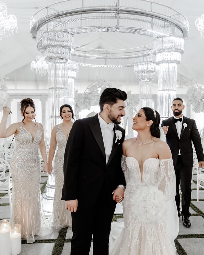 The wedding party celebrate behind the newlyweds after their wedding ceremony. 