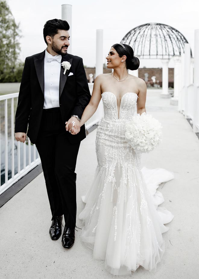 The bride and groom hold hands outside their Persian wedding at the Sans Souci Ballroom. 