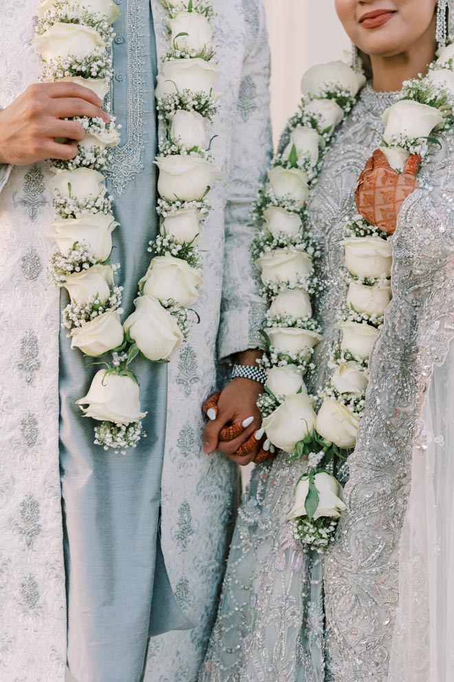 The bride and groom hold hands at their pastel Gulf Coast wedding in Galveston. 