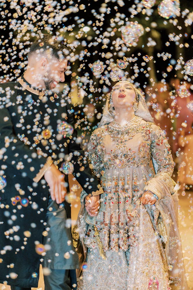 The bride and groom exit their wedding reception with a bubble send-off. 