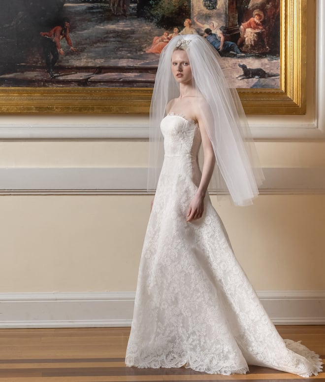 Strapless lace wedding gown with a tulle waist-length veil. 