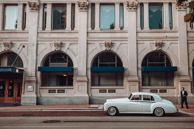 A blue vintage car parked in front of Hotel ICON. 