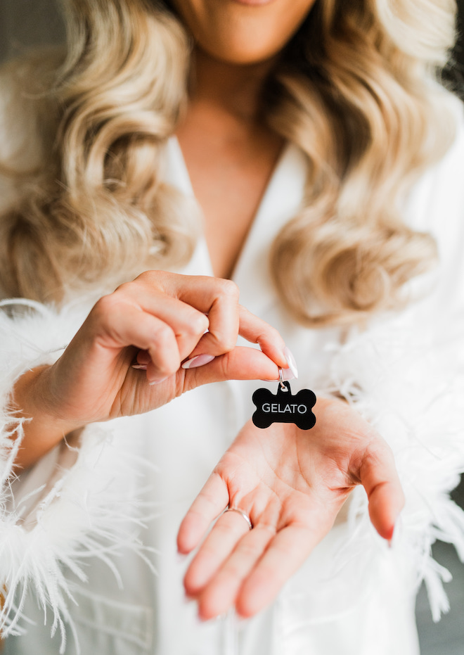 The bride holding up a black bone name tag reading "Gelato".