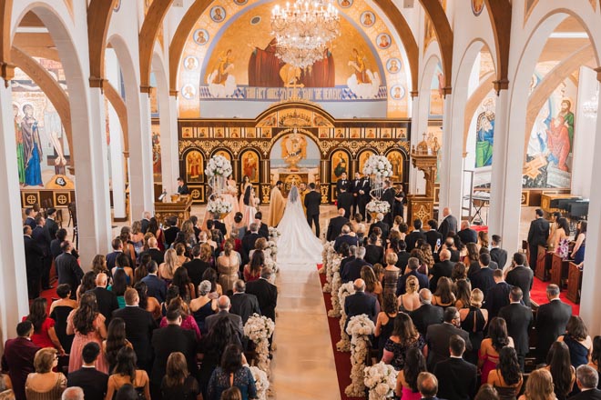 The bride and groom stand on the altar at their traditional wedding ceremony.