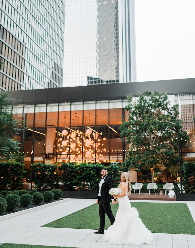 The bride and groom holding hands in front of The C. Baldwin Hotel. 