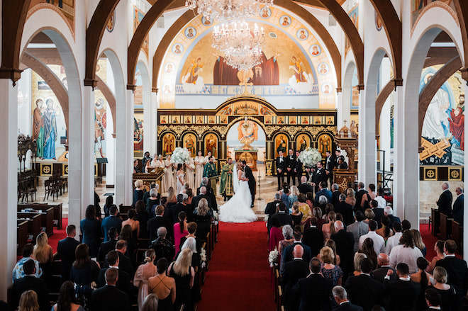 The bride and groom kissing at the altar. 