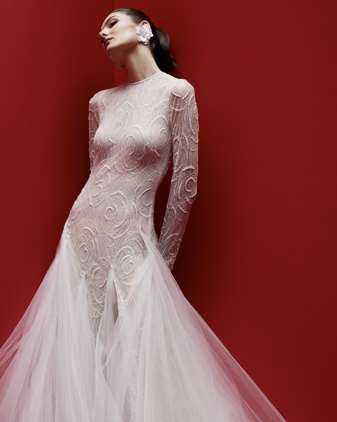 A fitted long-sleeve textured mermaid gown with a tulle skirt. 