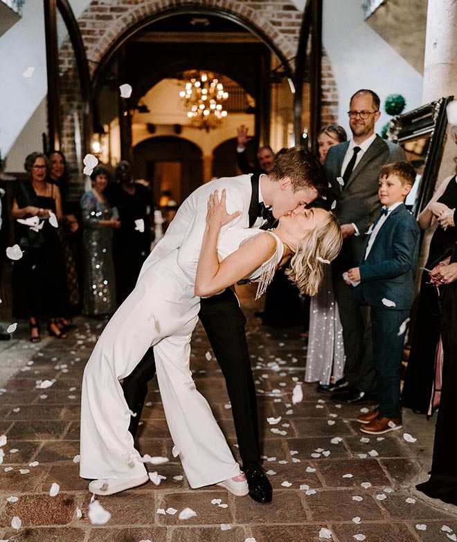 The bride and groom kissing as they exit The Bell Tower on 34th. 