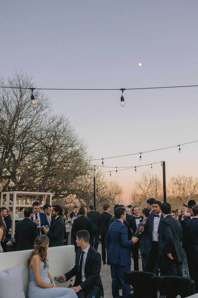 Wedding guests enjoy a sun-kissed al fresco cocktail hour before the reception.