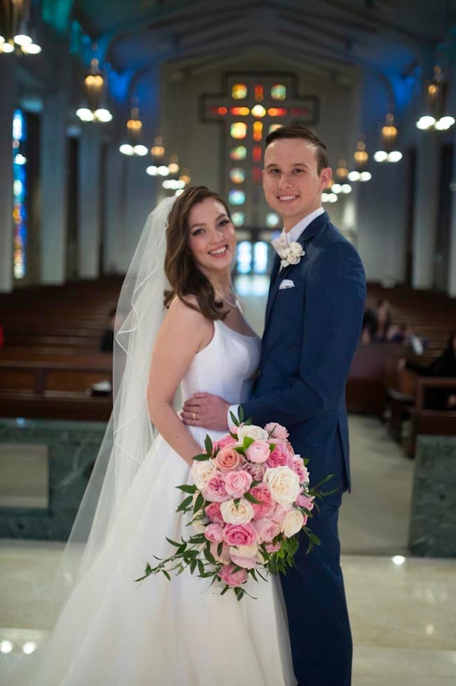 The bride and groom smile in the chapel where their wedding ceremony was held. 