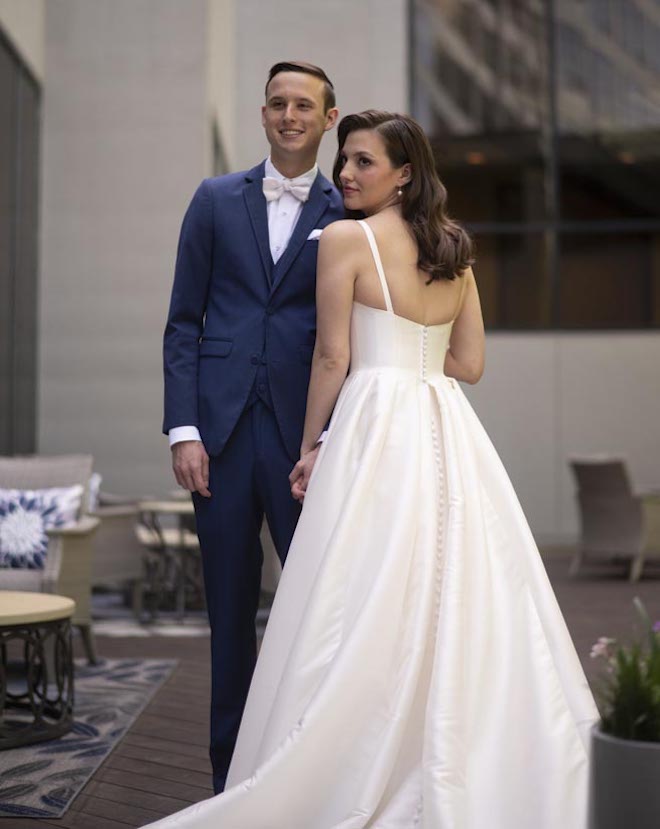 The bride and groom wed with a pink and navy ballroom wedding in Houston. 