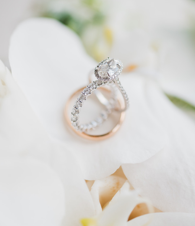 Three wedding bands stacked together on flower petals. 