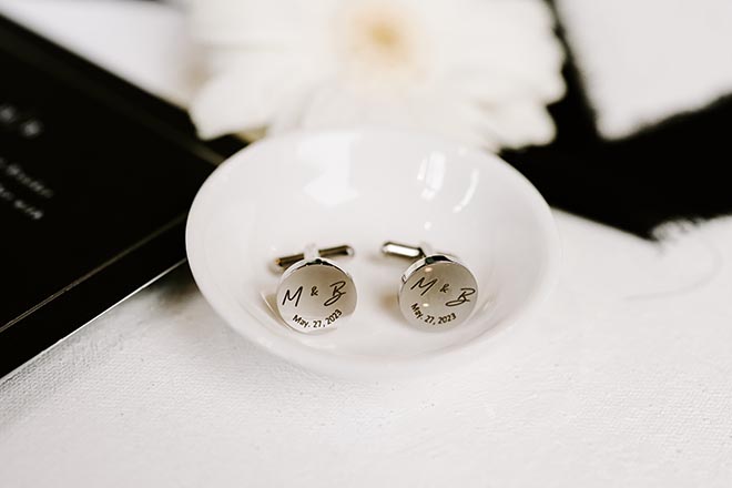 Silver cufflinks engraved with an M & B and the date May, 27, 2023. 