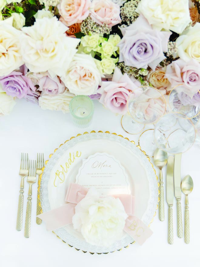 Gold chargers and silverware set the table for the dinner party.