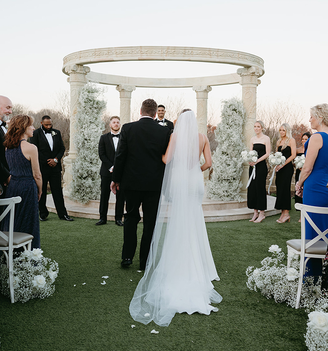 The bride and her father reaching the end of the aisle in front of the groom. 