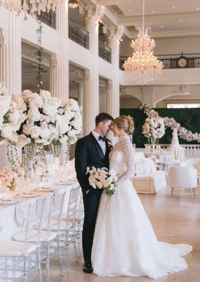 A bride and groom touching foreheads in the Corinthian Houston with blush and white decor.