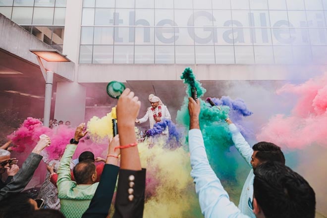 Yellow, pink, green and orange colors decorate the air outside of The Westin Galleria Houston at the groom's baraat.